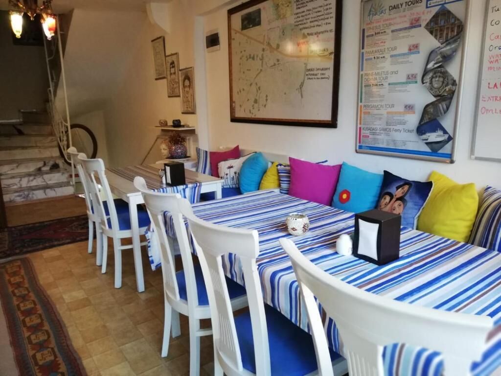 A dining area with a large map on the wall, a menu board, and a staircase leading to an upper level.