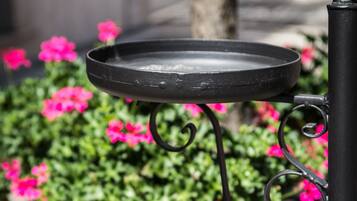 Una mesa de metal con superficie negra, sujeta a un soporte de metal negro de diseño curvo.