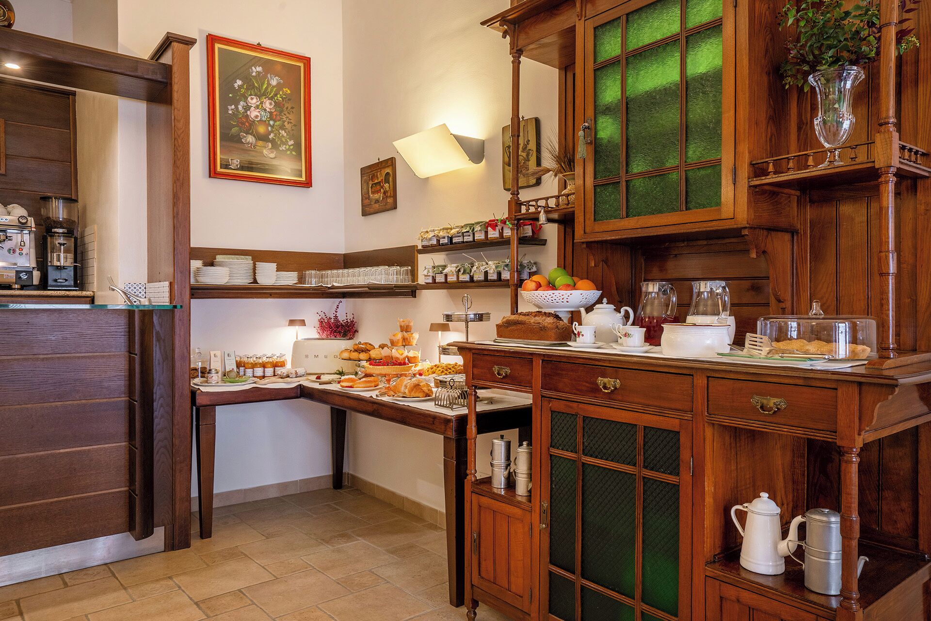 Una cocina con armarios de madera, una cafetera y varios productos para el desayuno sobre la encimera.