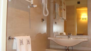 Ein Badezimmer mit einem großen Waschbecken, einem Handtuchhalter und einem Spiegel.