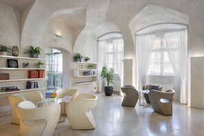 Een ruime woonkamer met moderne meubels, een glazen deur naar buiten en uitzicht over de stad.