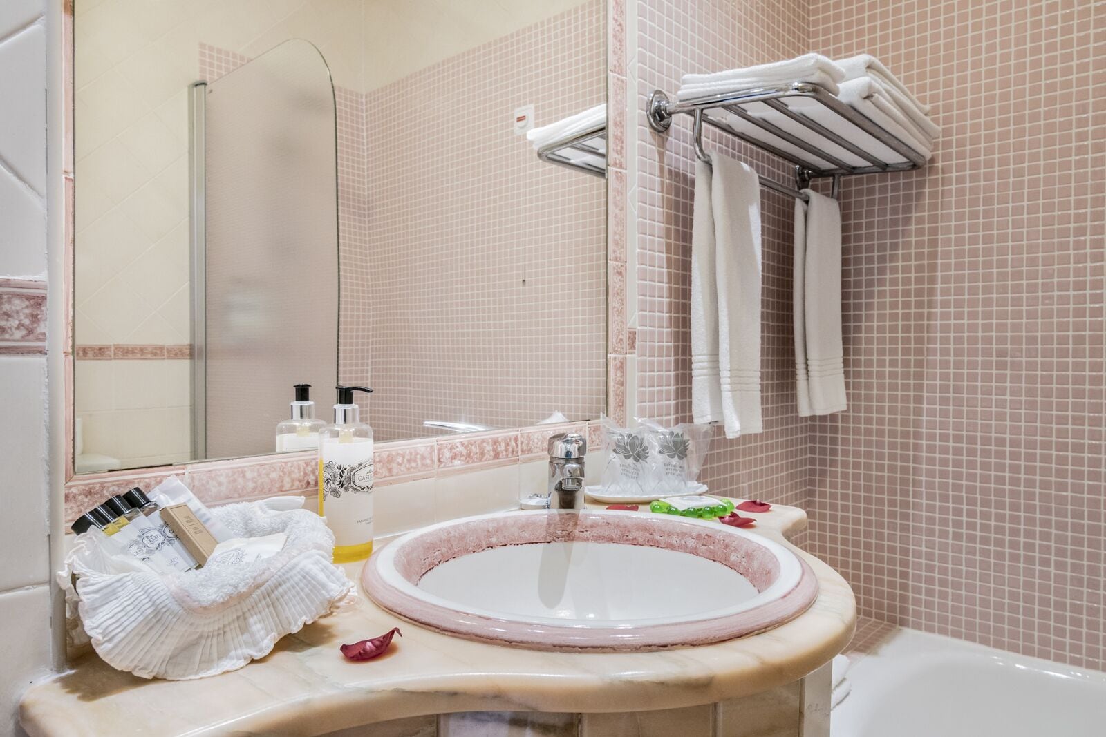 Une salle de bain avec un lavabo rond, un miroir et un porte-serviettes.