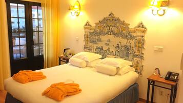 Una habitación de hotel con una cama grande, dos mesitas de noche y vistas a través de una ventana.
