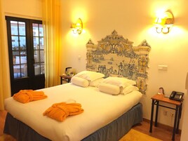 Una habitación de hotel con una cama grande, dos mesitas de noche y vistas a través de una ventana.