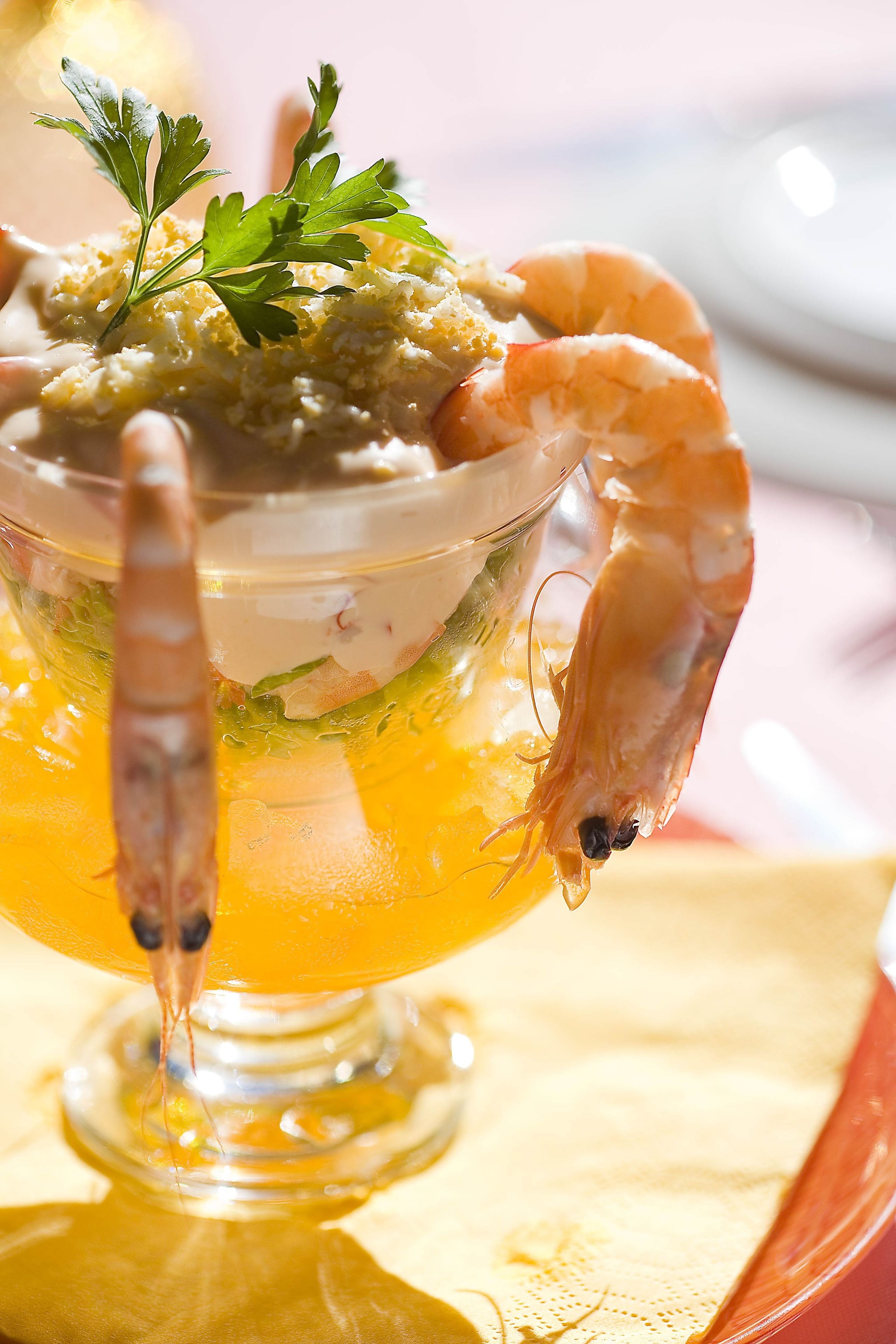 A shrimp cocktail with a garnish, served in a glass.