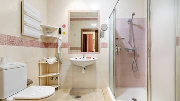 Un baño con inodoro, lavamanos y ducha.