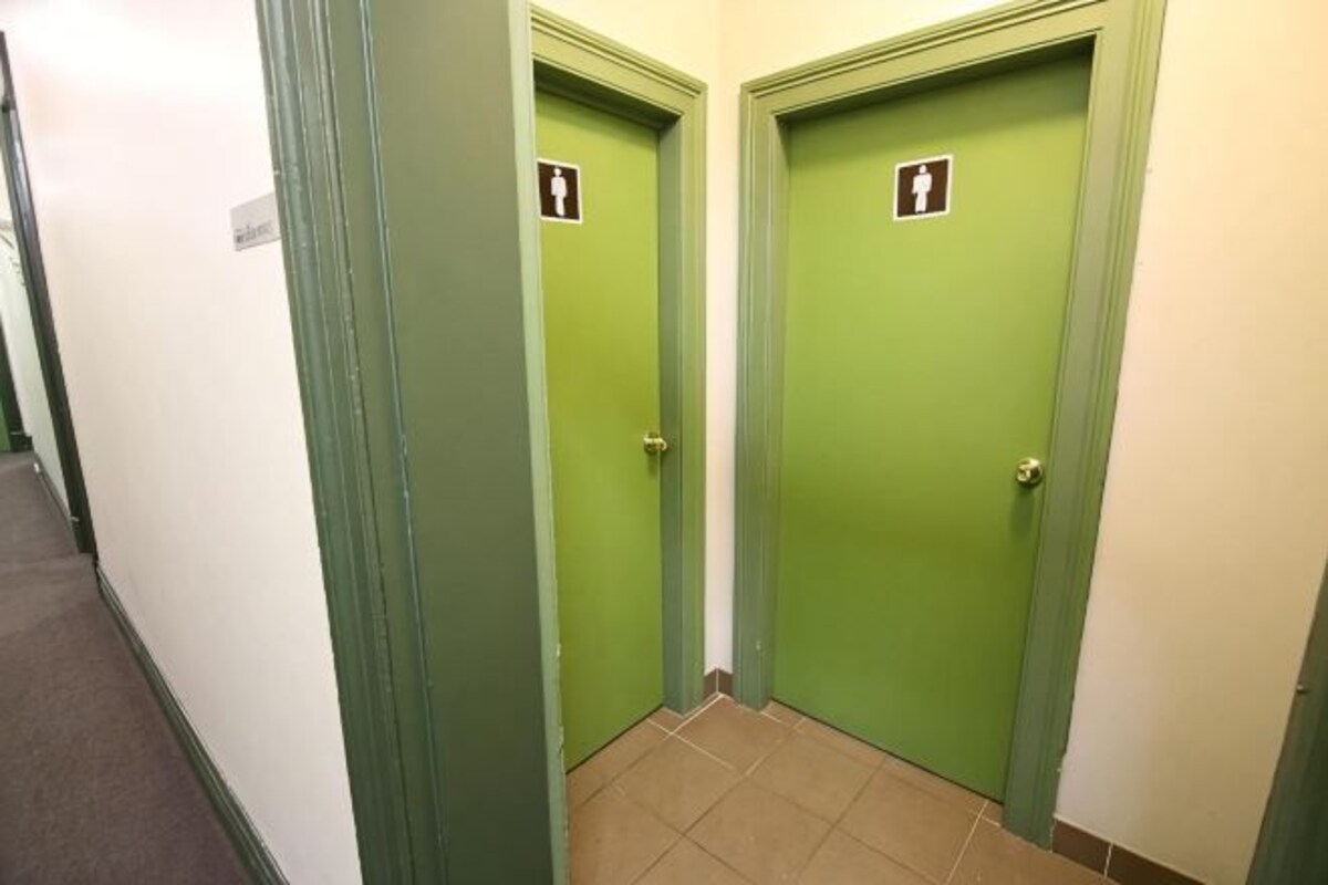 A hallway with two green doors, each marked with a wheelchair accessibility sign.