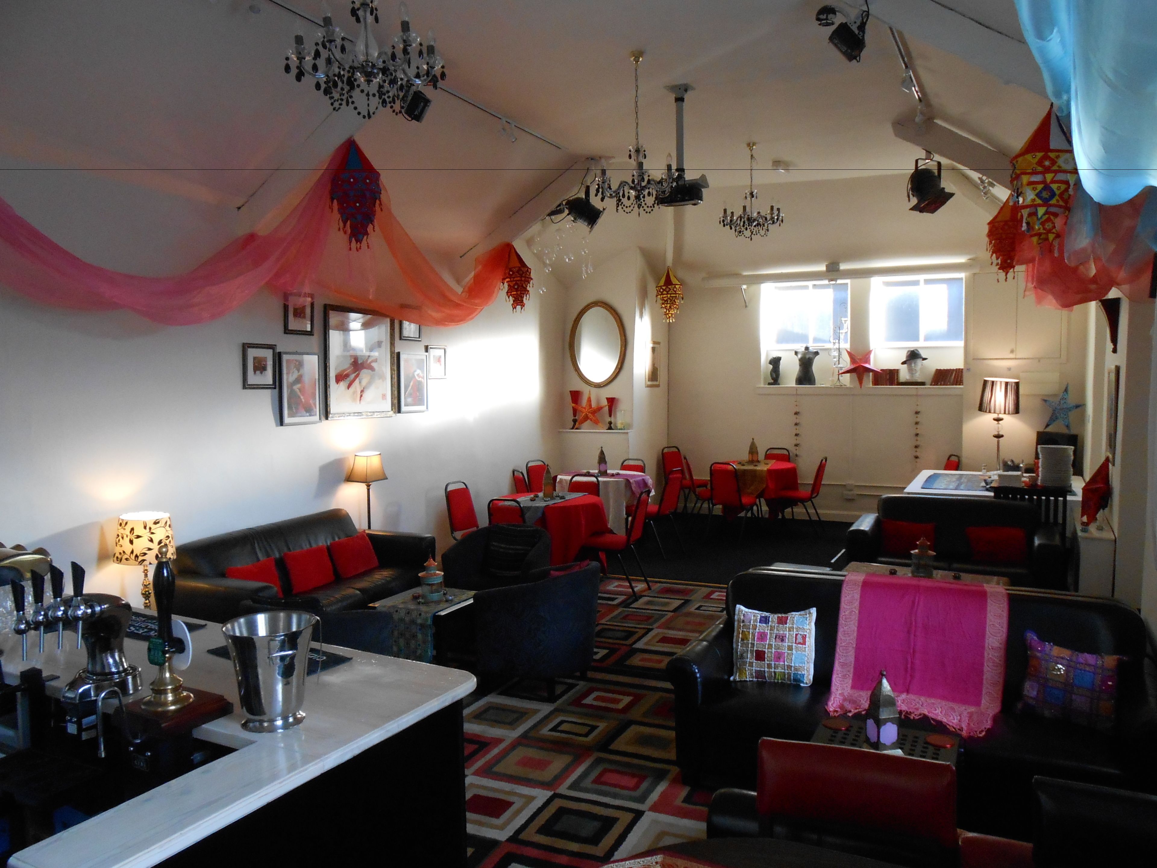 A hotel room with a dining area, a sofa, a coffee table, and a chandelier.