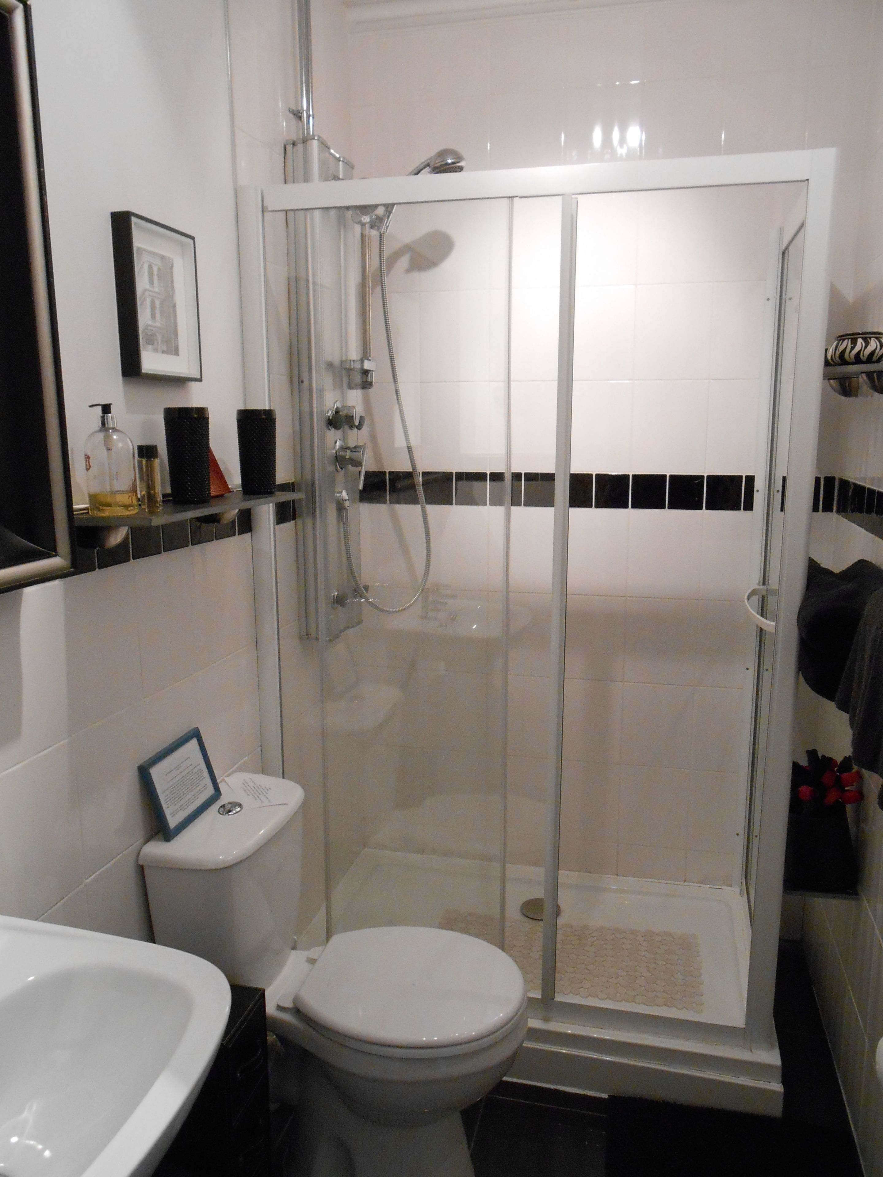 A bathroom with a glass-enclosed shower, a toilet, and a sink.