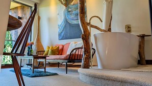 A modern interior with a wooden staircase, a large abstract painting, and a white bathtub. - The Cartford Inn (Preston)