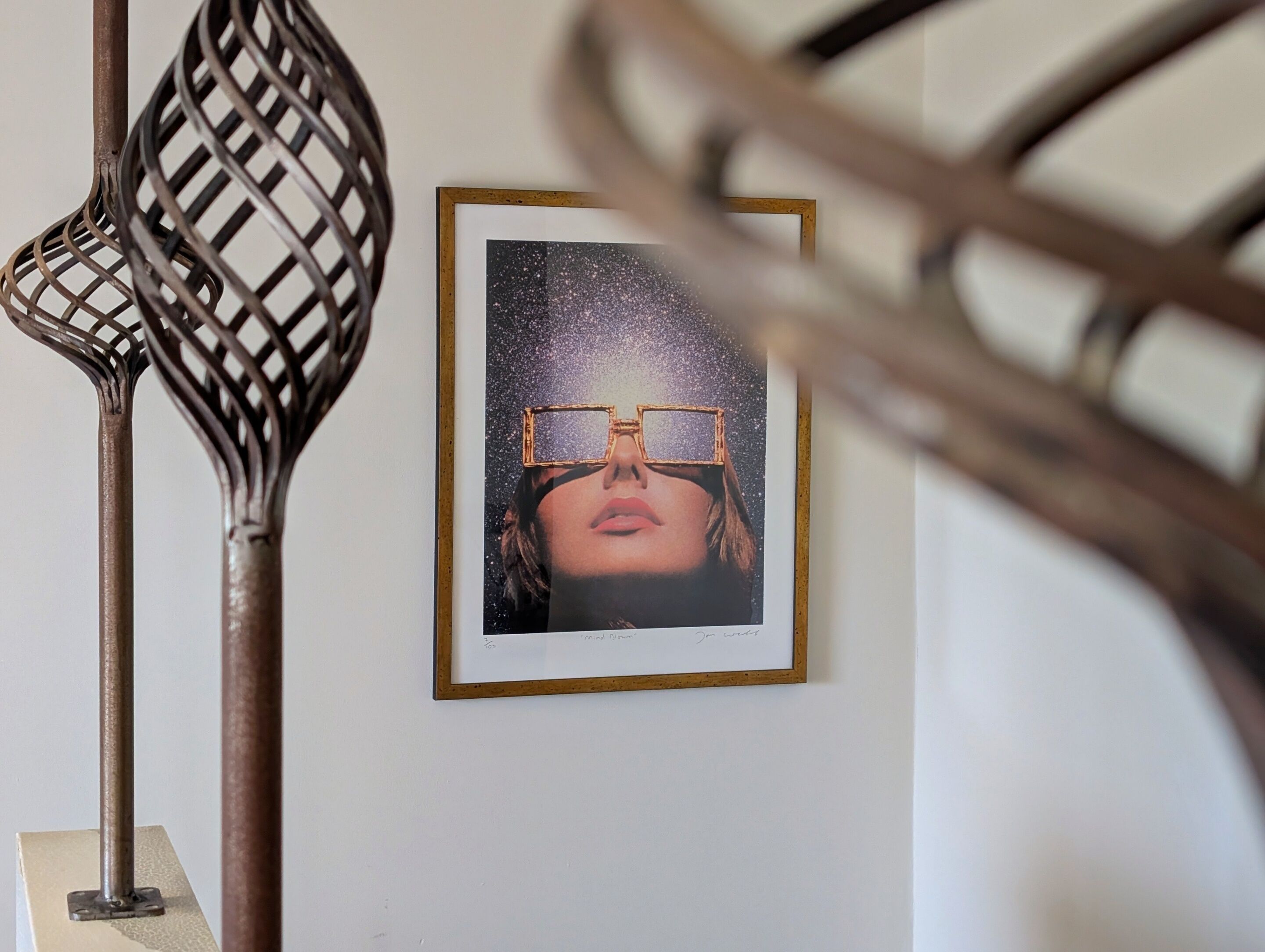 A framed photograph of a person wearing glasses on a wall.