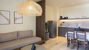 Un salon moderne comprenant un canapé, une table basse et un coin repas avec des chaises et une table.