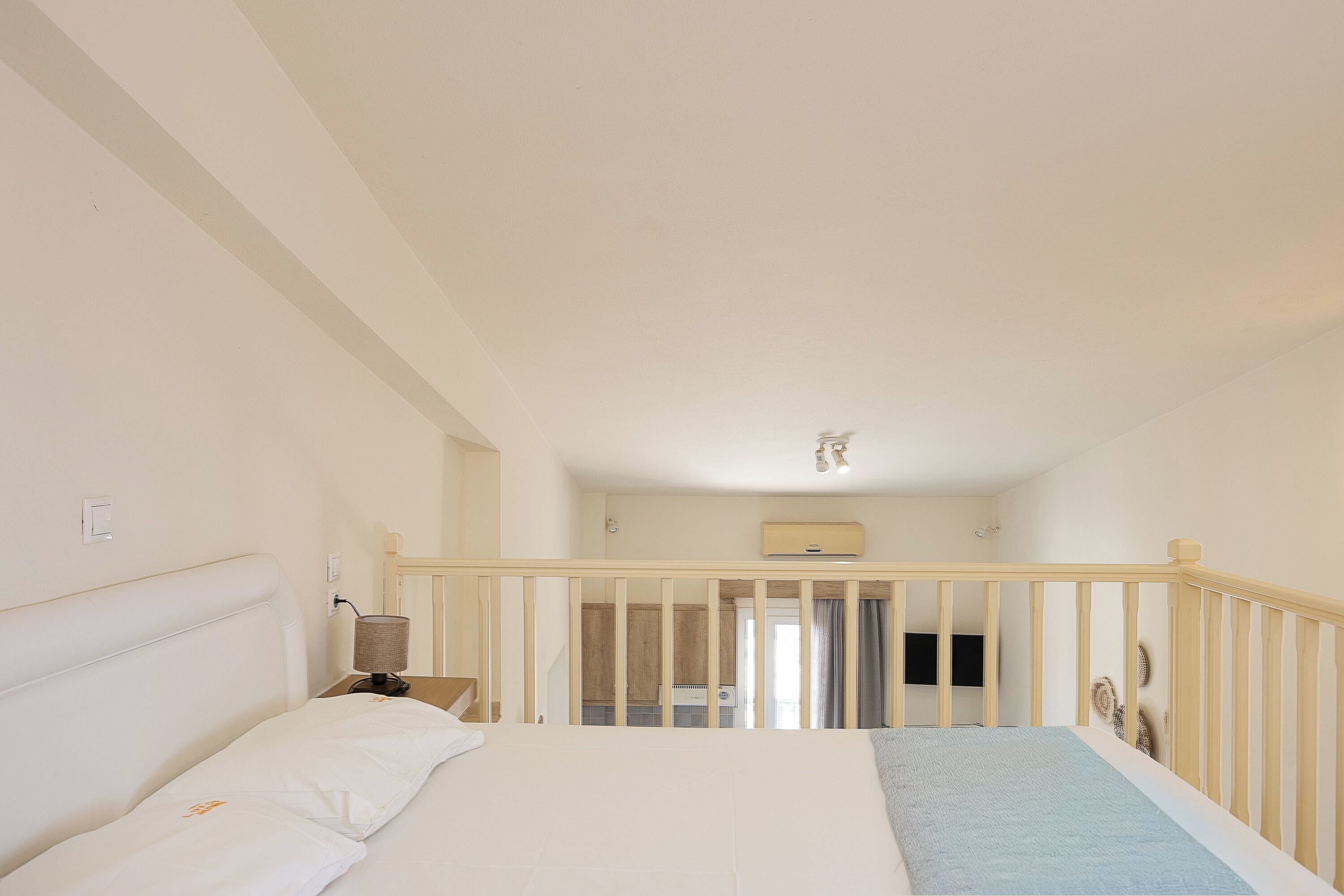 Una camera da letto con un letto, un comodino, una lampada e una ringhiera in legno.