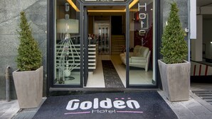 The entrance to the Golden Hotel with a clear view of the interior through the glass doors. - Golden Hotel (Naples)