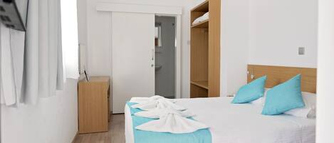 Ein Hotelzimmer mit einem Bett, einem Holzschrank, einem Schreibtisch und einem Spiegel.