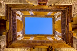 A square room with ornate wooden doors and intricate ceiling designs.