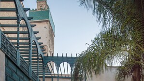A courtyard with a pool, lounge chairs, and a staircase. - Dar Bensouda (Fes)