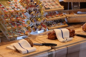 A bakery display with various pastries and a cutting board with a knife. - Hotel Restaurant Mattmarkblick (Saas Almagell)