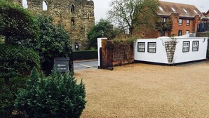A gravel courtyard with a white building, a stone wall, and a sign for Veolia. - Castle House Hotel (Canterbury)