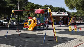 Un parque infantil con columpios y un tobogán.