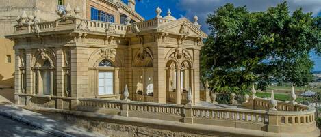 A historic building with classical architecture, featuring arched windows and decorative balustrades.