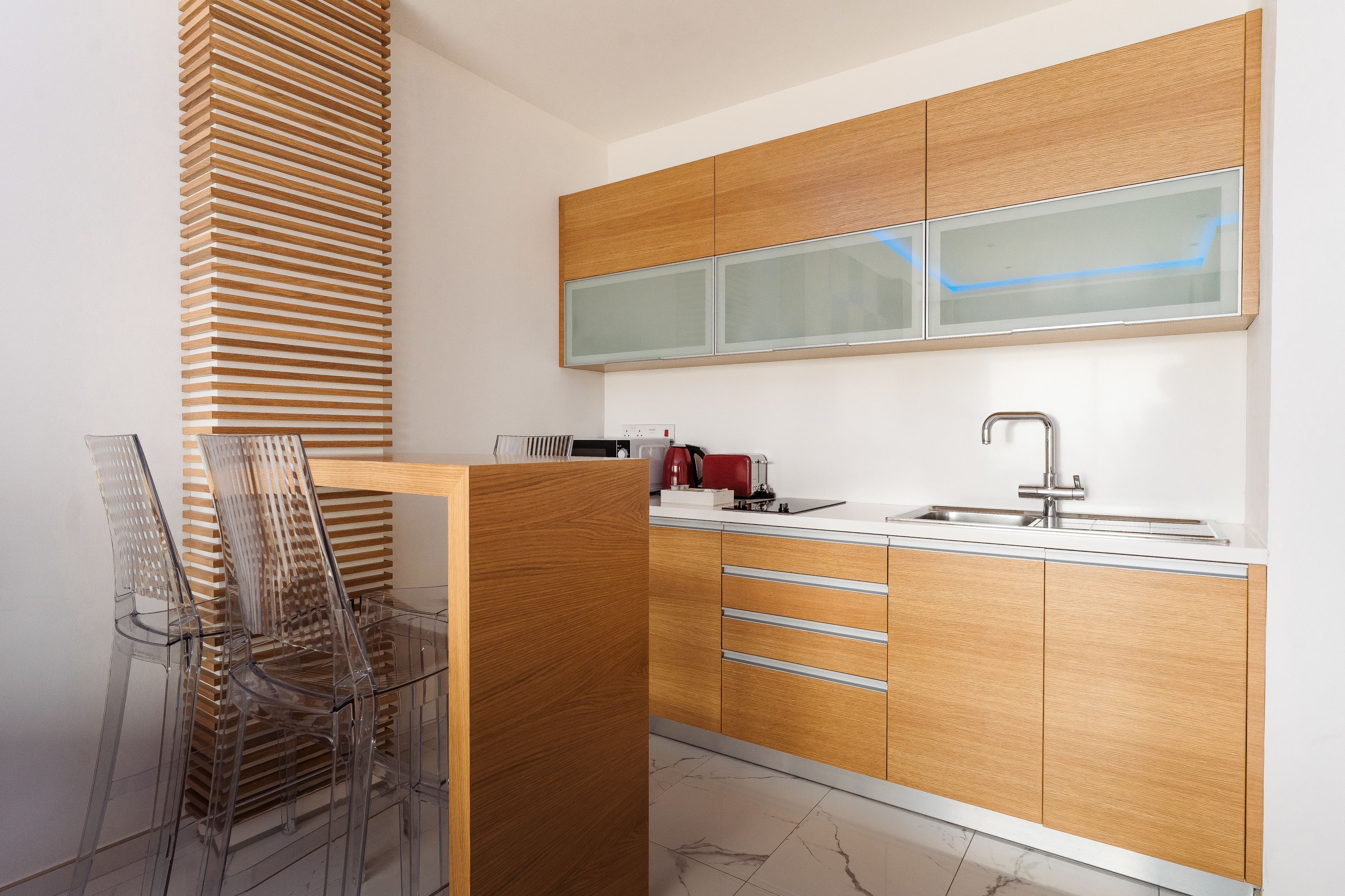 Una cocina moderna con armarios de madera, un lavamanos de acero inoxidable y un ventanal.