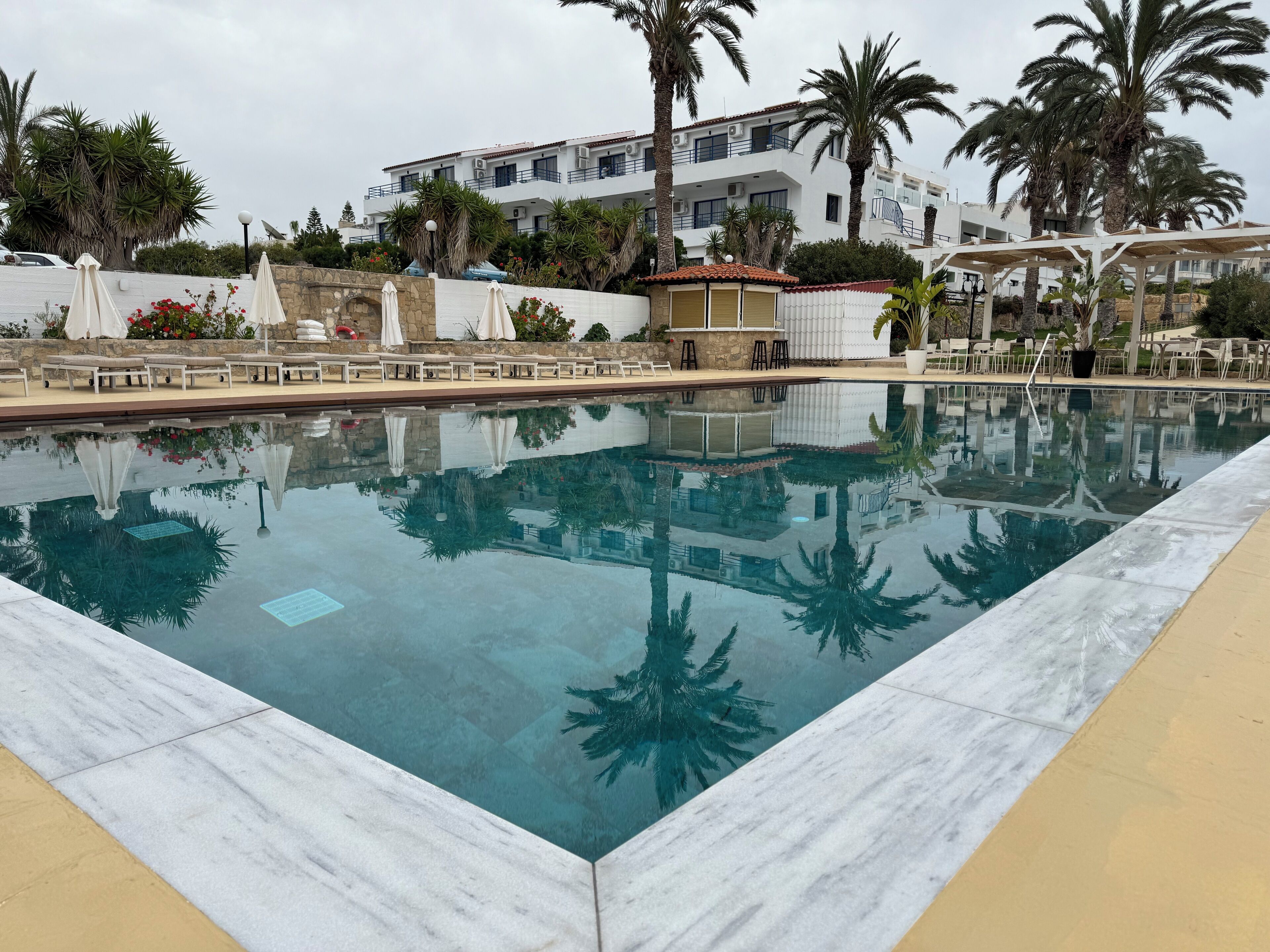 Una piscina al aire libre de temporada, sombrillas