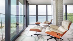 Una habitación moderna con ventanas amplias, un balcón y muebles contemporáneos.