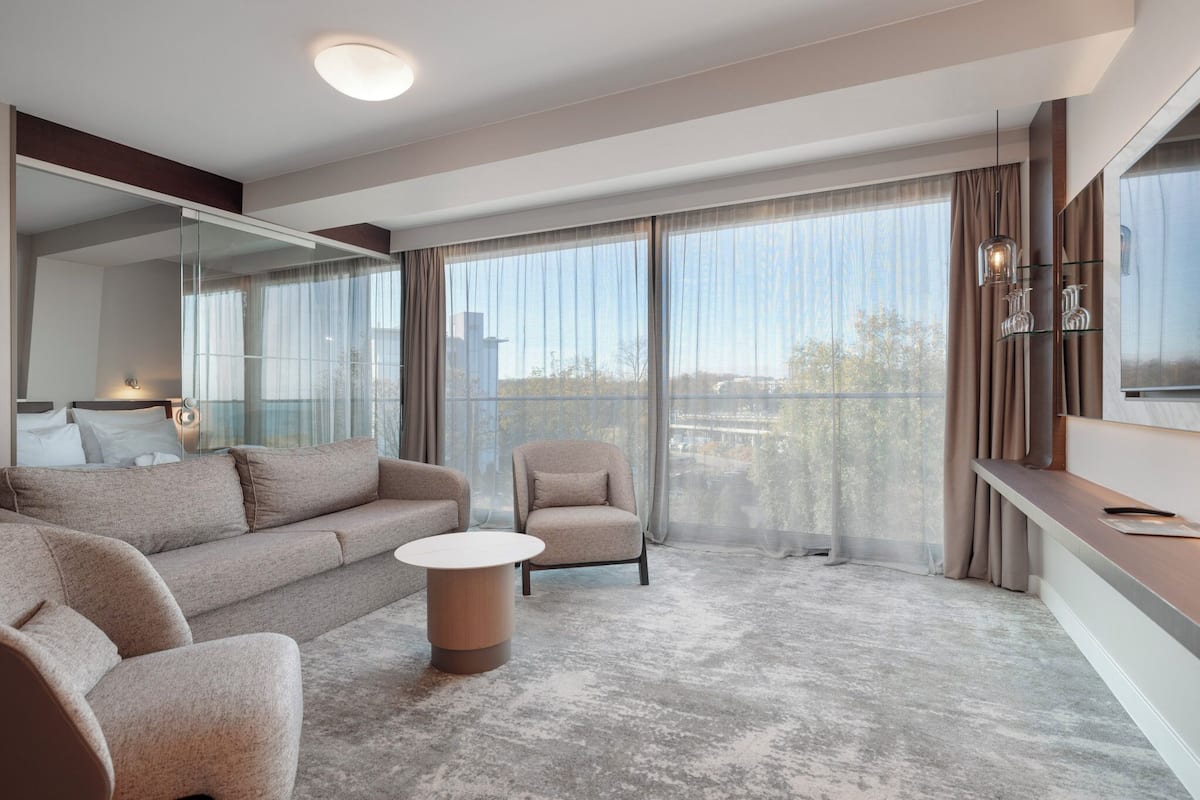 A modern living room with a sofa, armchair, and round coffee table.