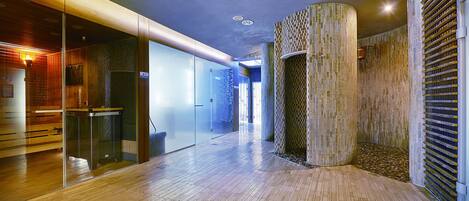 Un interior moderno con suelo de madera, separaciones de vidrio y una pared con textura única.