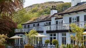 A traditional building with a balcony, outdoor seating, and potted plants. - Rothay Manor Hotel (Ambleside)