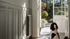 A hallway with a dog sitting by a door leading to a garden. - Rothay Manor Hotel (Ambleside)