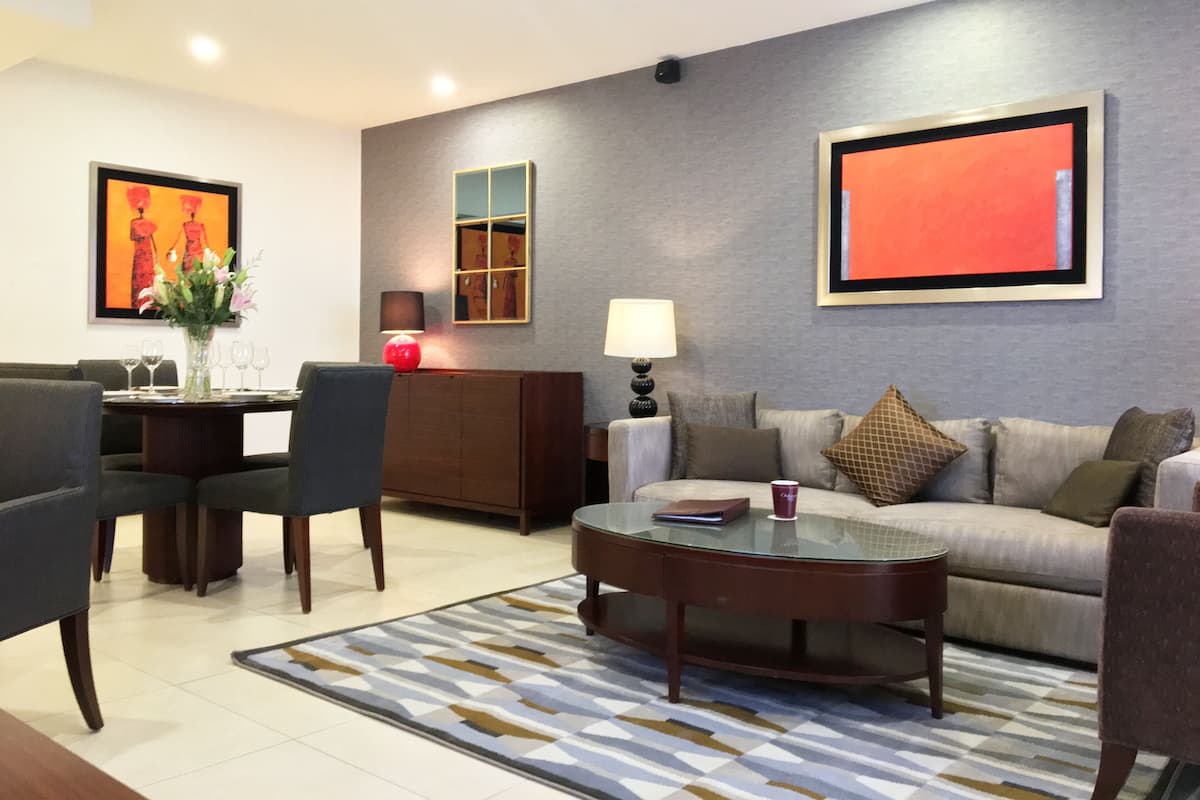 A modern living room with a sofa, coffee table, and dining area.