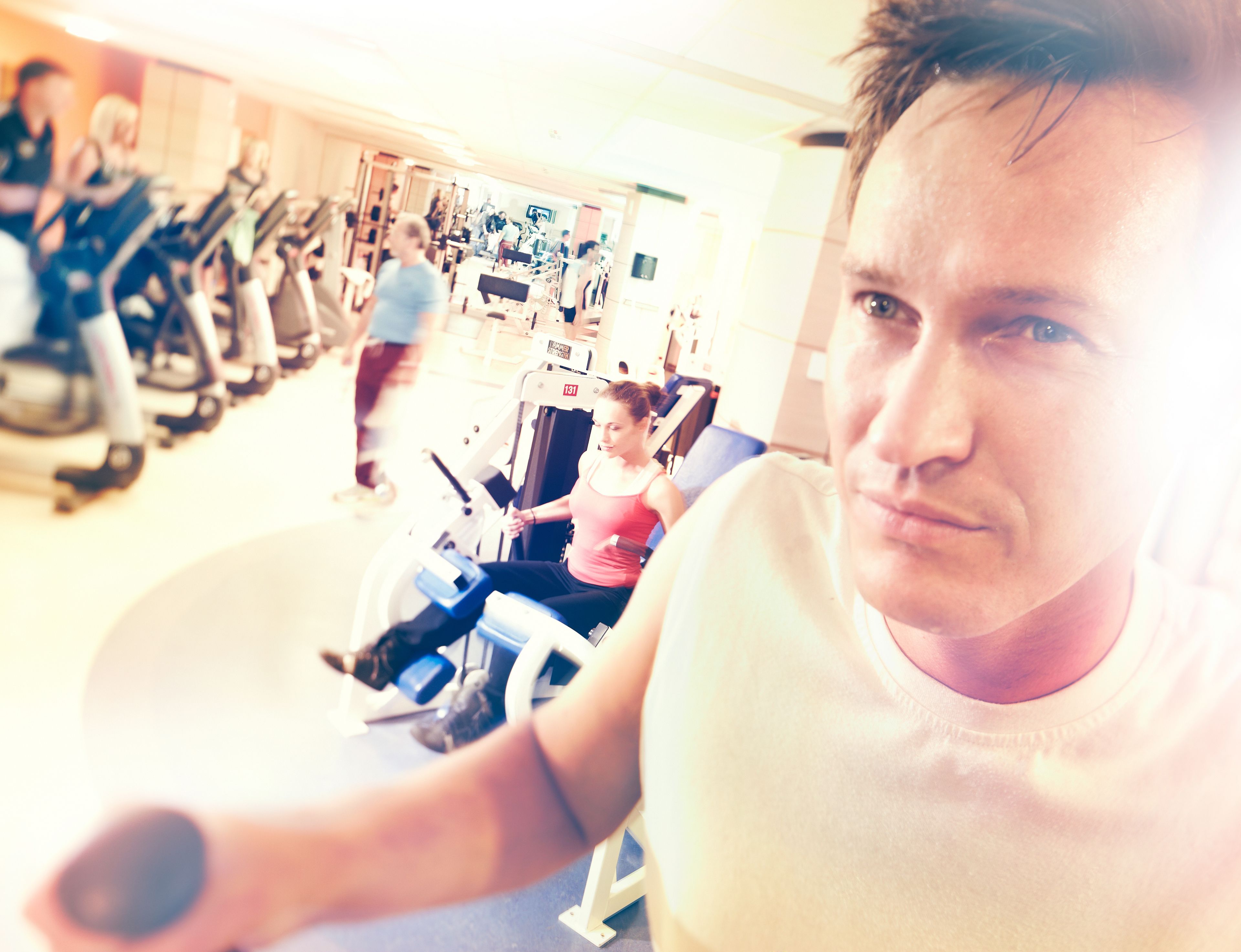 Une salle de sport équipée de matériel d’exercice, où une personne utilise un vélo d’appartement.