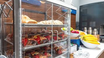 Vitrine de pastelaria com doces e lanches embalados.