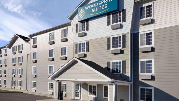 A multi-story hotel with a sign reading "Woodspring Suites". - WoodSpring Suites Baton Rouge East I-12 (Baton Rouge)