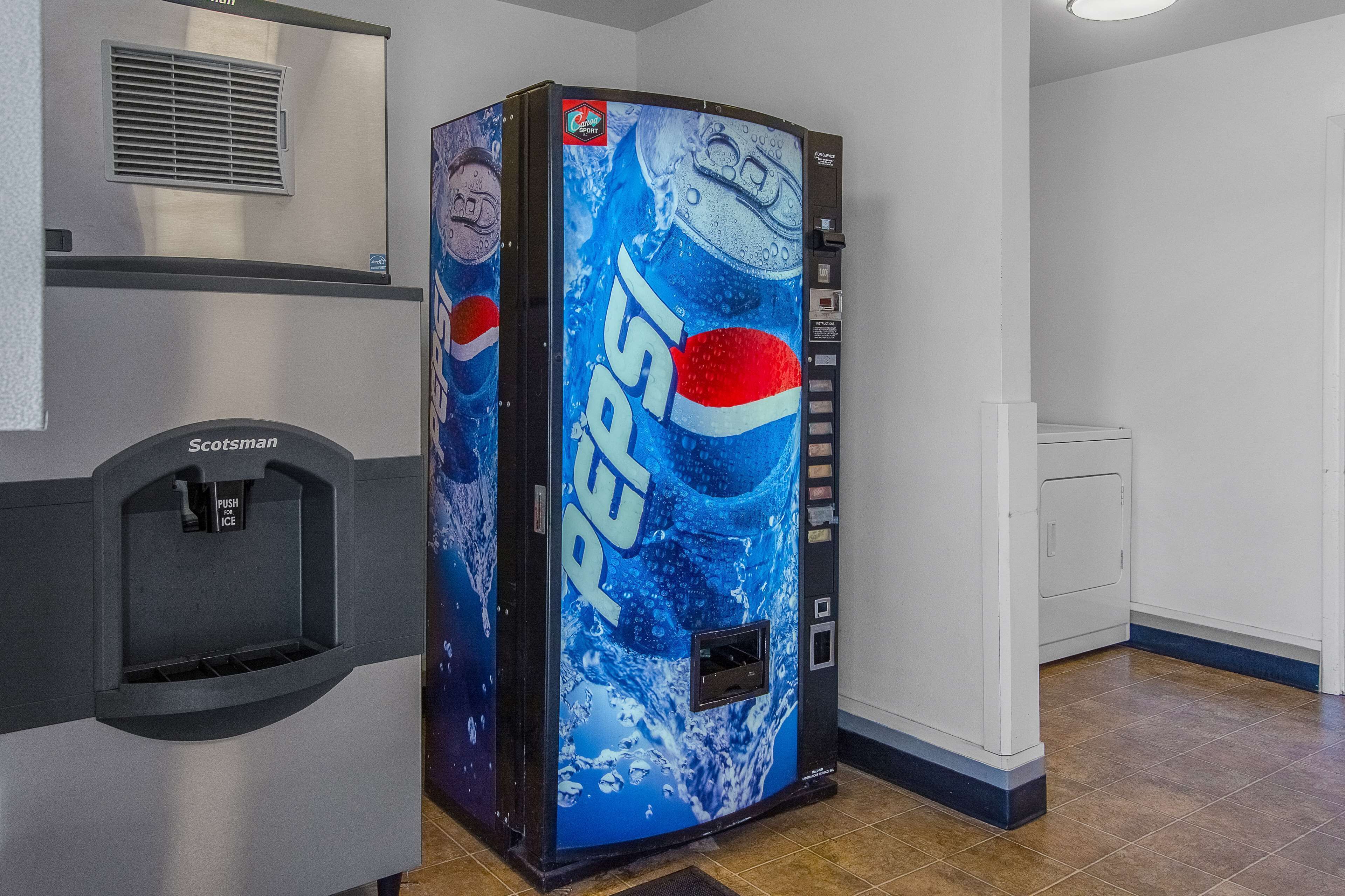 A vending machine with a Pepsi logo, a push ice dispenser, and a coin slot.