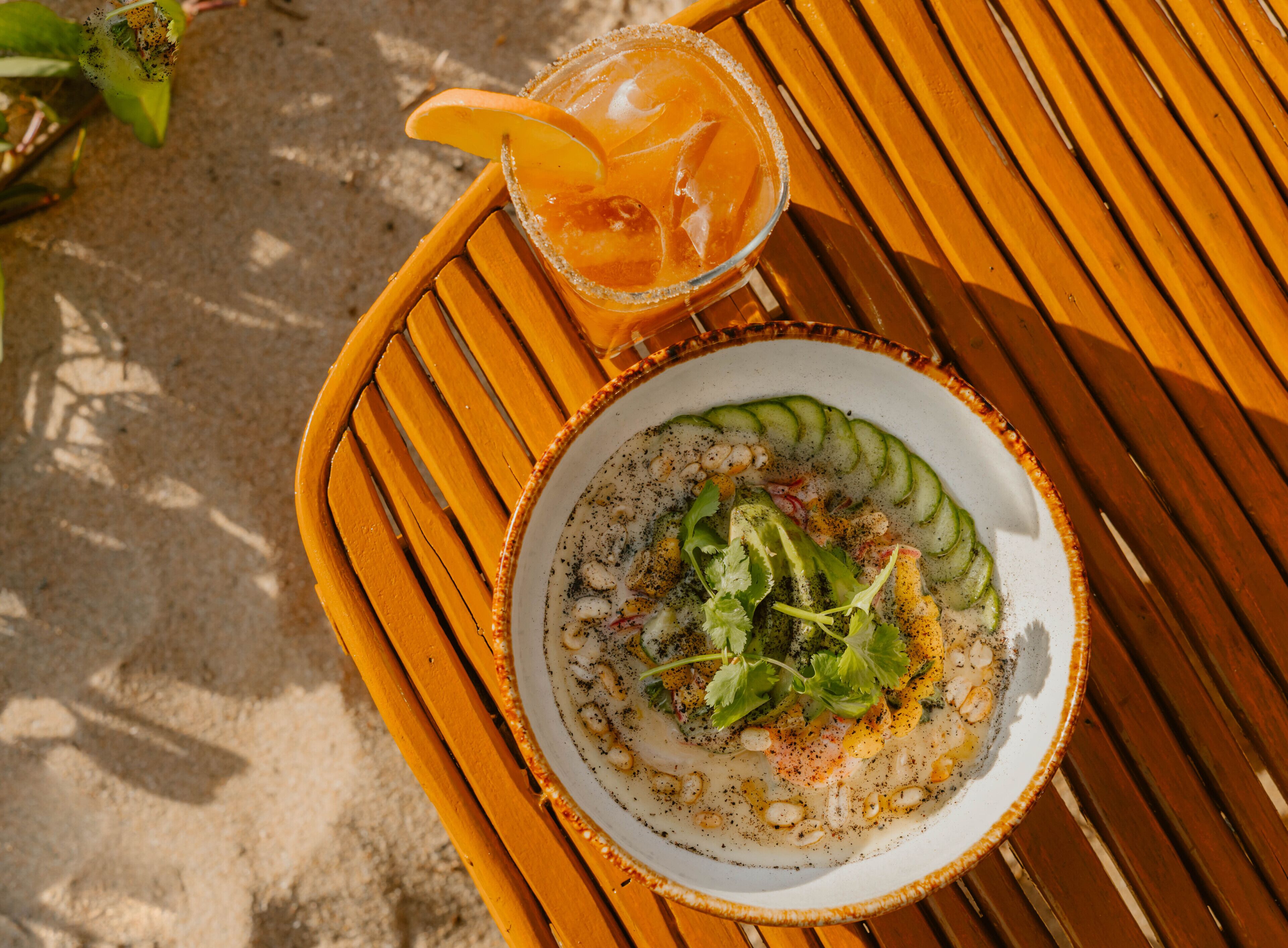A plate of seafood salad with a slice of lemon on a wooden table.