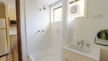 Ein Badezimmer mit Badewanne, Dusche, Waschbecken und einem Fenster.