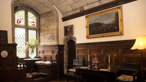 A traditional library room with wooden furniture, a fireplace, and stained glass windows. - Tower (Mold)