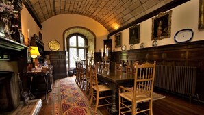 A traditional dining room with a long wooden table, chairs, and a patterned rug. - Tower (Mold)