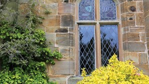 A stone building with a large arched window featuring stained glass. - Tower (Mold)