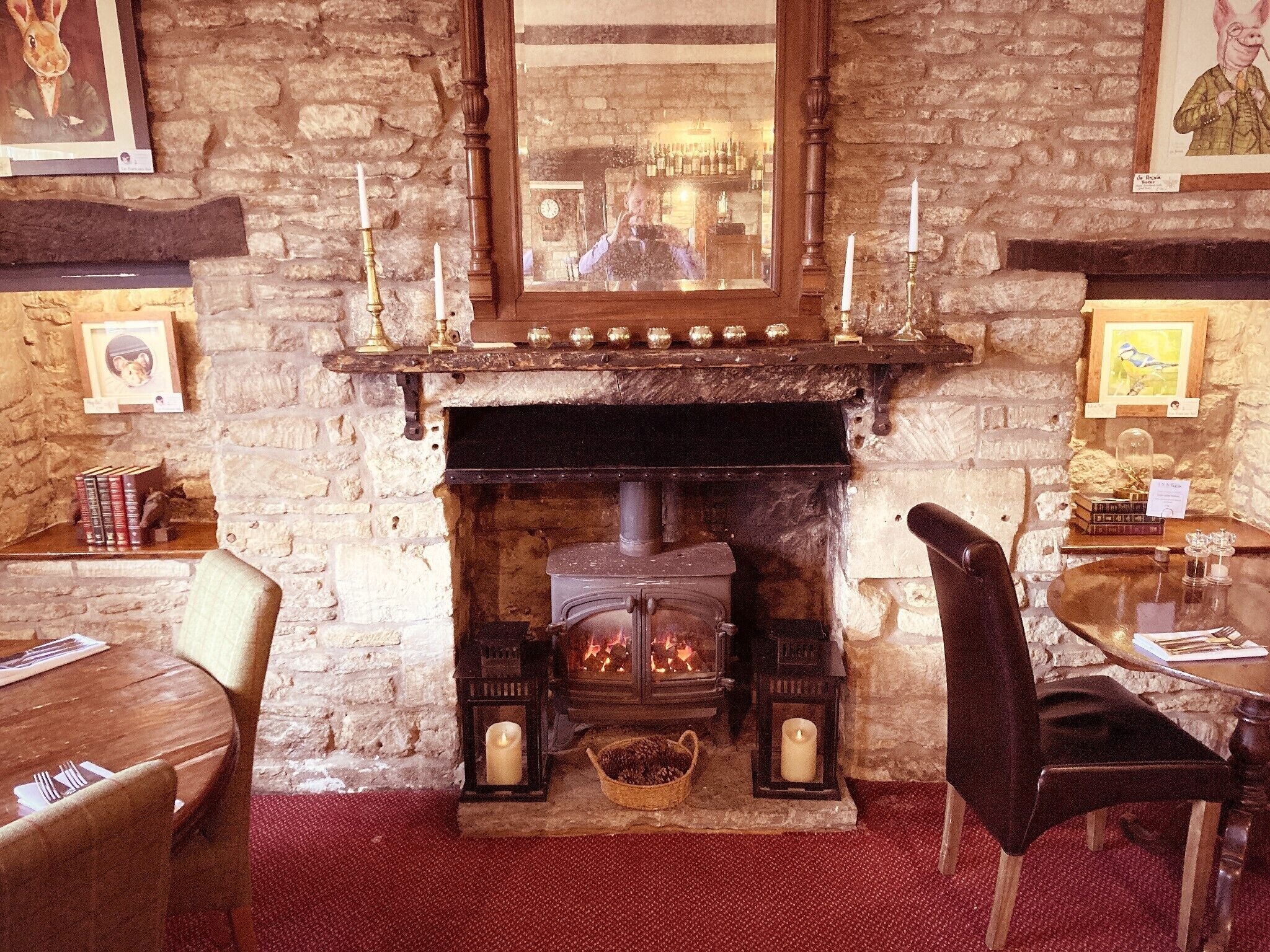 Una habitación acogedora con chimenea de piedra, muebles de madera y cuadros en las paredes.