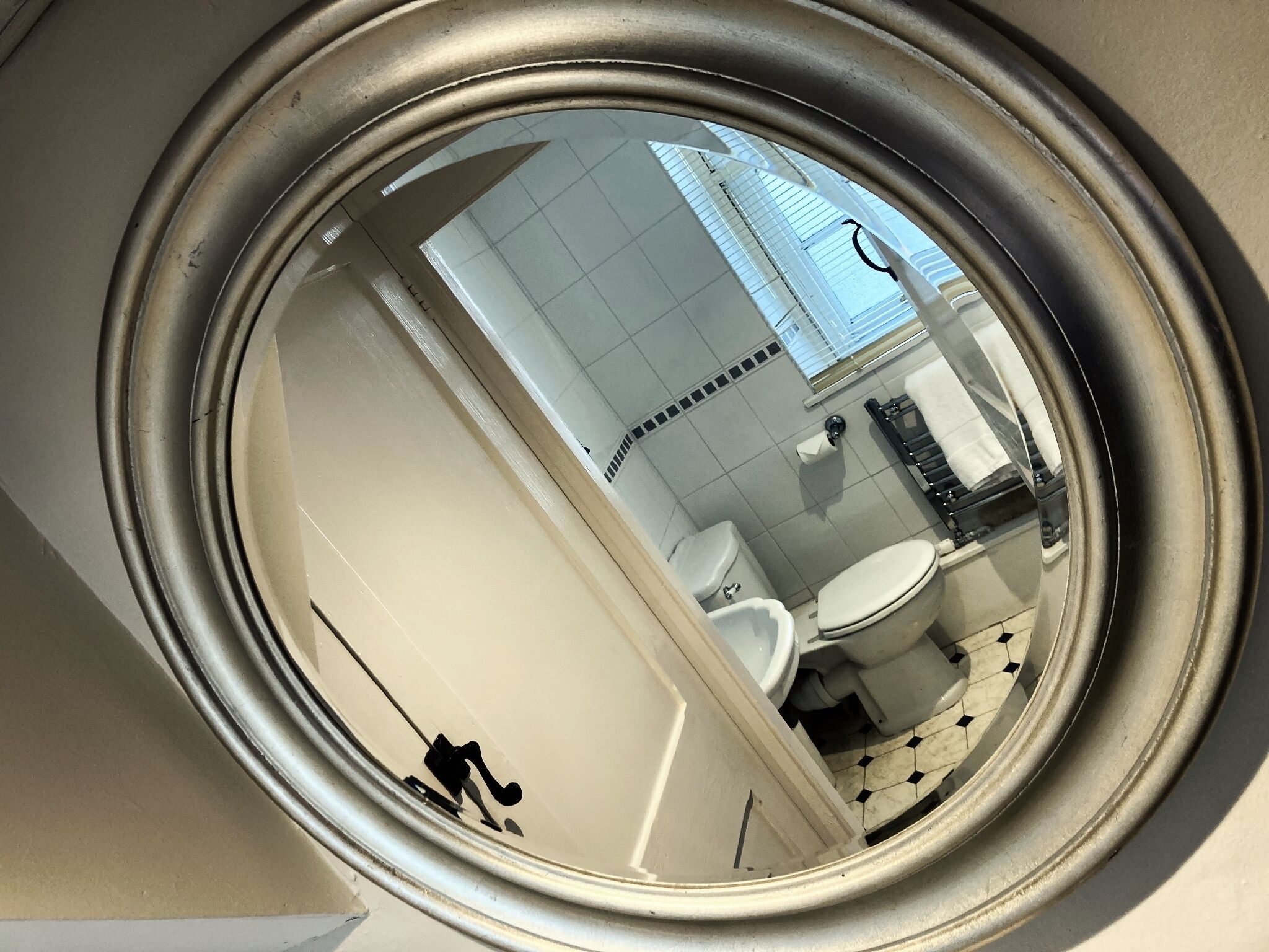 A bathroom with a toilet, sink, and mirror.