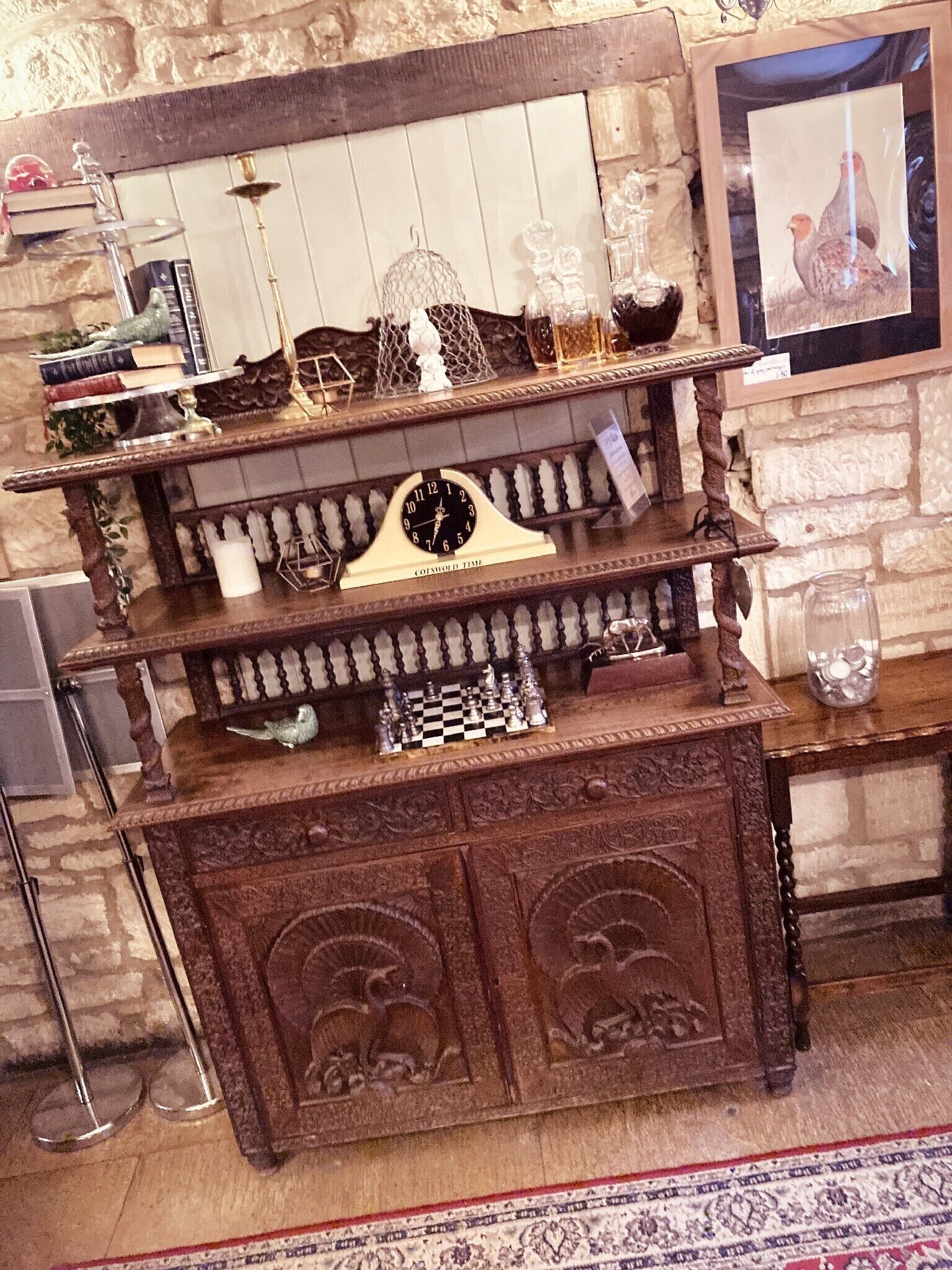 A wooden display shelf with a clock, chess set, and decorative items.