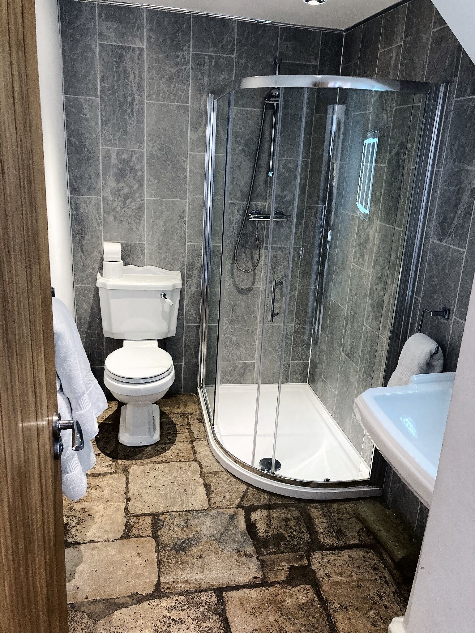 A bathroom with a glass-enclosed shower, a toilet, and a bathtub.