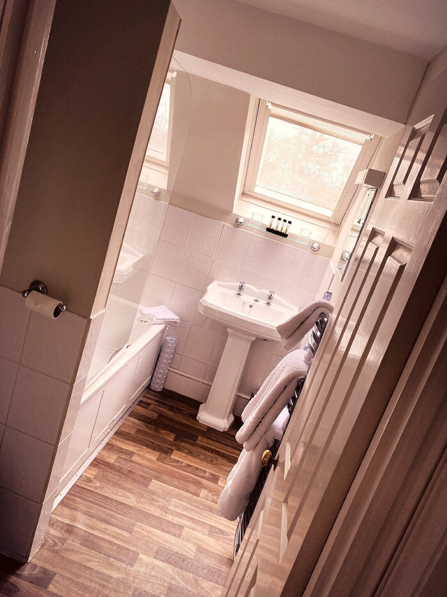 Een badkamer met toilet, wastafel en raam.