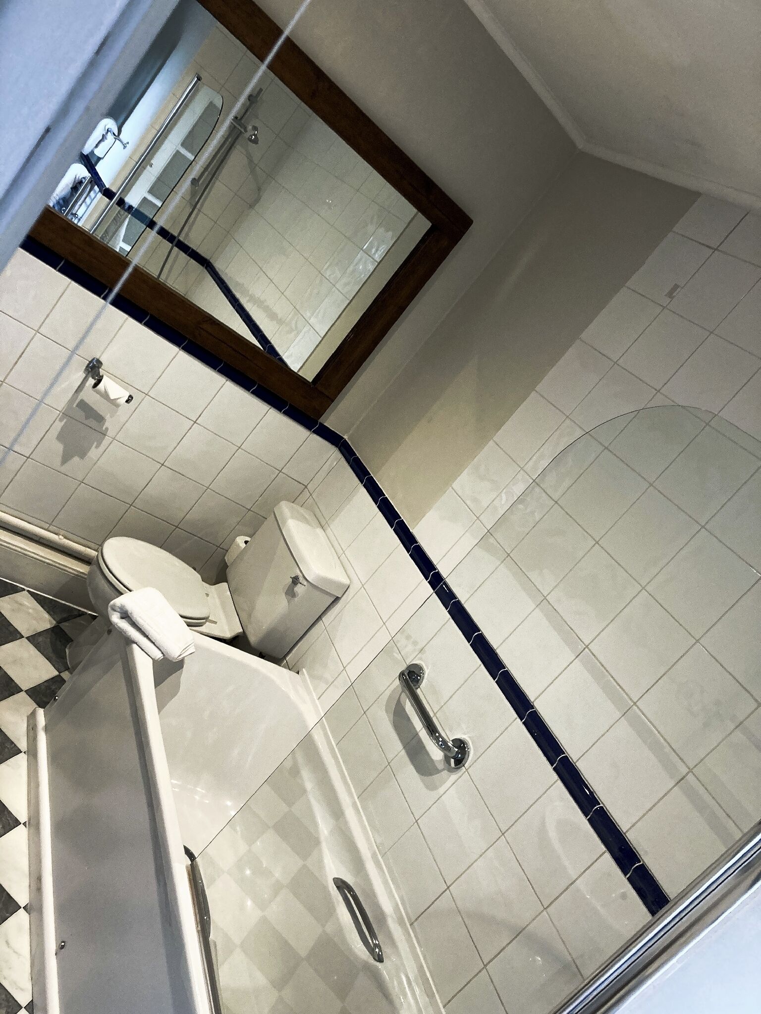 Un baño con inodoro, lavamanos y espejo.