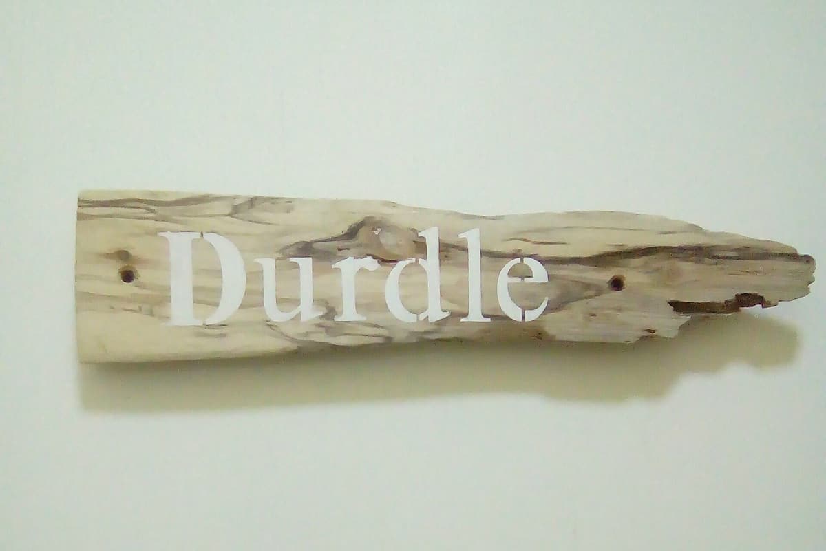 A wooden sign with the word "Durdle" on it.