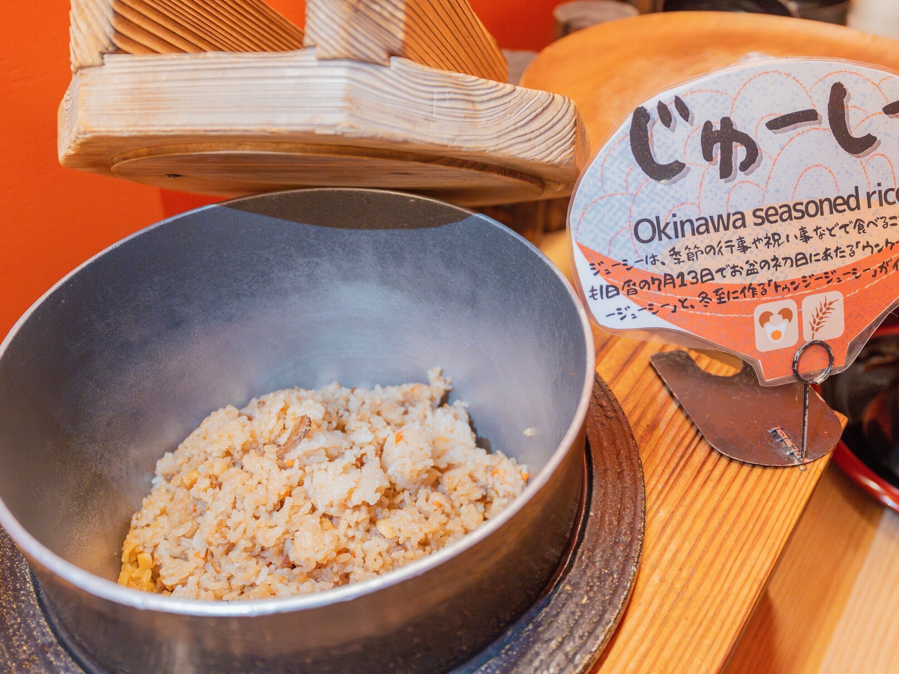 Un tazón de arroz sazonado con una etiqueta que indica que es arroz al estilo Okinawa.
